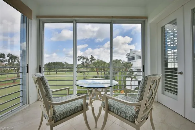 a dining room with furniture and a floor to ceiling window