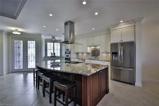 a kitchen with stainless steel appliances granite countertop a sink a stove and a refrigerator