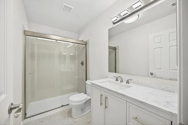 a bathroom with a double vanity sink toilet and shower