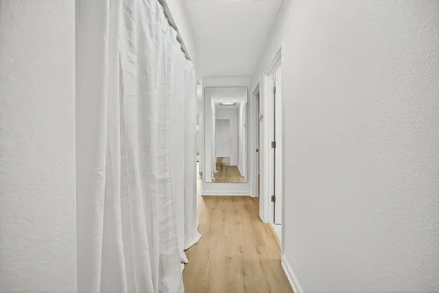 a view of a big room with wooden floor closet and windows