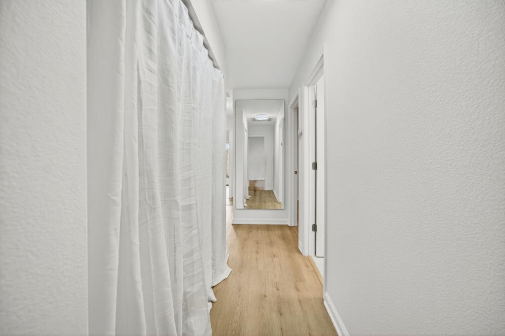 6237 Riverbelle Court Rio Linda, CA 95673 - Photo 33 of 50 a view of a hallway with wooden floor and a bathroom