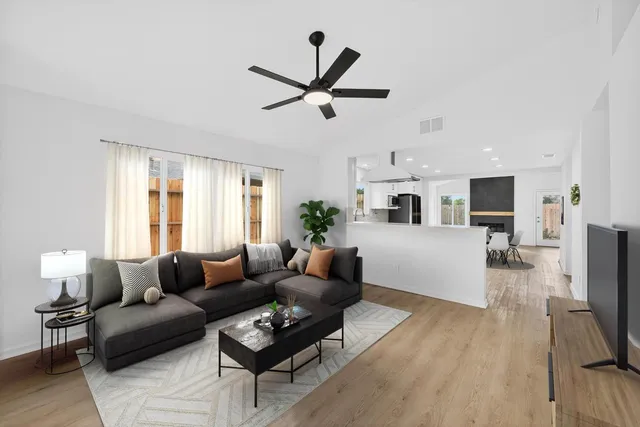 a living room with furniture a flat screen tv and a window
