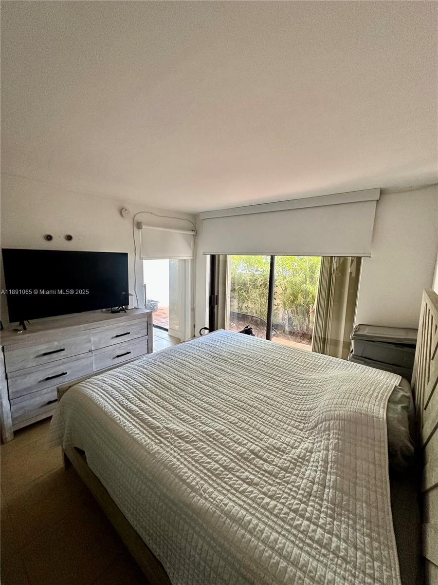 1650 Northeast 115th Street, Unit 102 Miami, FL 33181 - Photo 12 of 18 a bedroom with a bed and a television