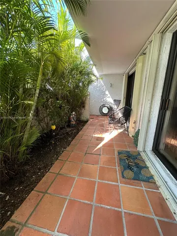 a view of a backyard with floor to ceiling window and potted plants