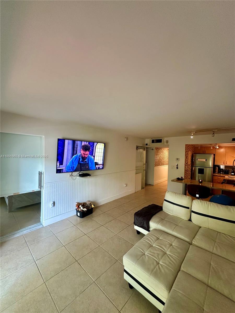 1650 Northeast 115th Street, Unit 102 Miami, FL 33181 - Photo 5 of 18 a living room with furniture and a flat screen tv