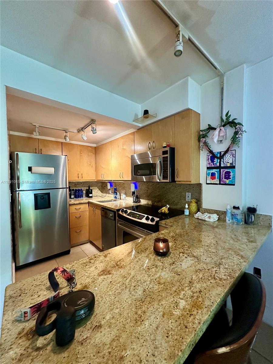 1650 Northeast 115th Street, Unit 102 Miami, FL 33181 - Photo 6 of 18 a kitchen with a stove a refrigerator and a sink