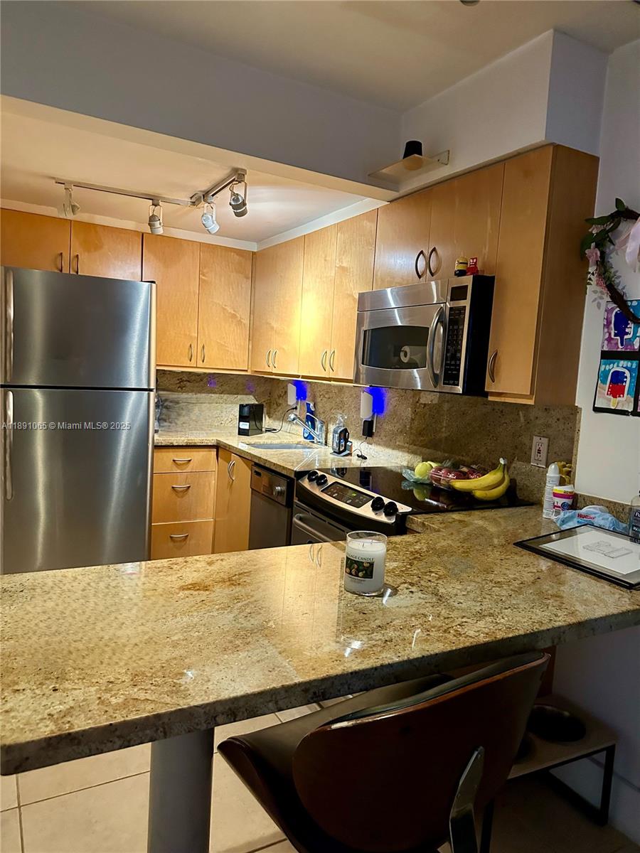 1650 Northeast 115th Street, Unit 102 Miami, FL 33181 - Photo 7 of 18 a kitchen with stainless steel appliances granite countertop a sink refrigerator and stove