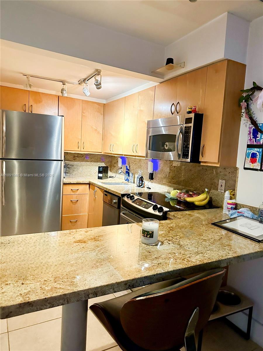 1650 Northeast 115th Street, Unit 102 Miami, FL 33181 - Photo 8 of 18 a kitchen with stainless steel appliances granite countertop a sink and a refrigerator