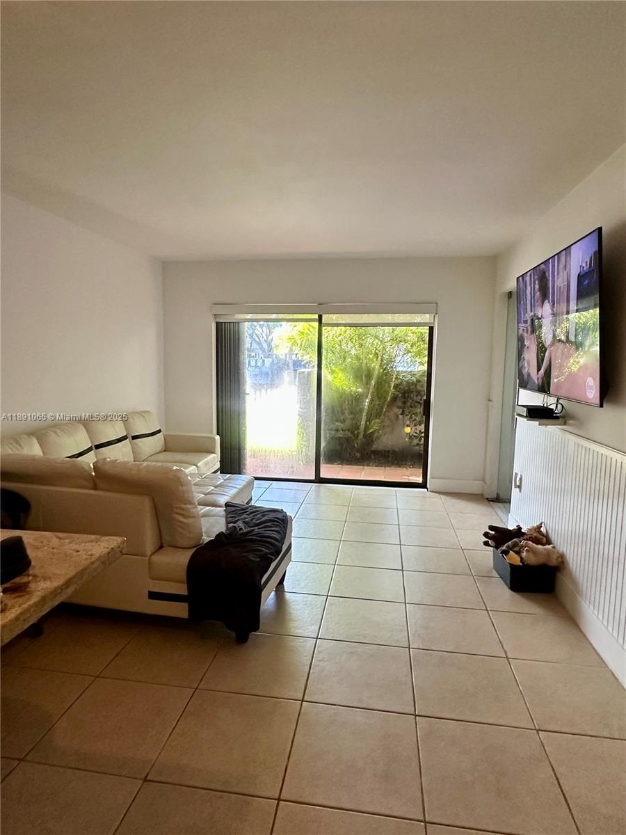 1650 Northeast 115th Street, Unit 102 Miami, FL 33181 - Photo 9 of 18 a living room with a couch and a window