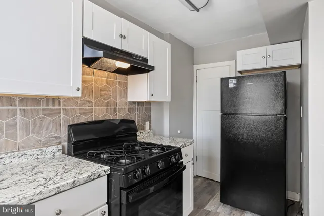 a kitchen with granite countertop a refrigerator and a stove