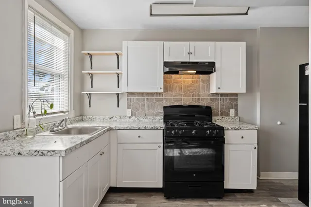 a kitchen with white cabinets and appliances