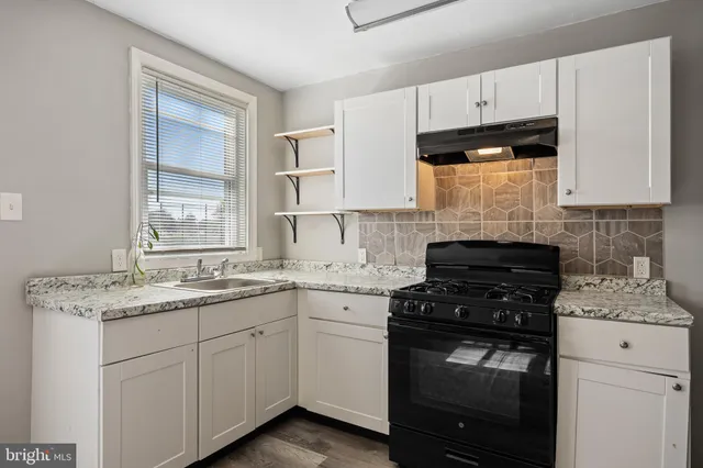 a kitchen with cabinets appliances a sink and a window