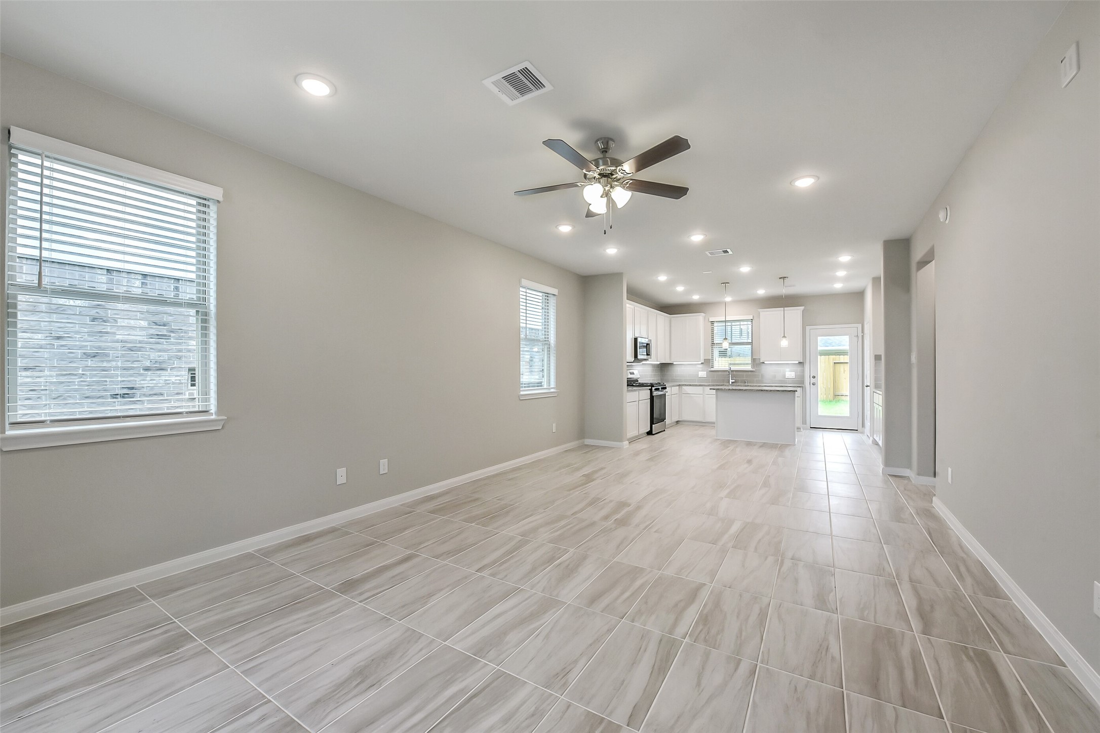 4318 Wind Swell Lane Houston, TX 77053 - Photo 7 of 39 a view of an empty room and a kitchen with wooden floor