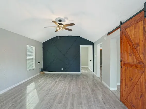 a view of room with hardwood floor and a ceiling fan