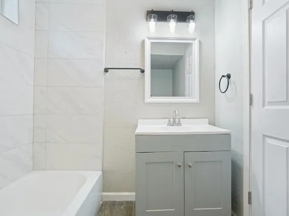 a bathroom with a granite countertop sink a toilet and shower