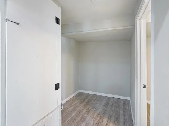a view of a small space with wooden floor and a window