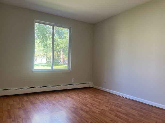 2300 Light Road, Unit 109 Oswego, IL 60543 - Photo 5 of 16 an empty room with wooden floor and windows