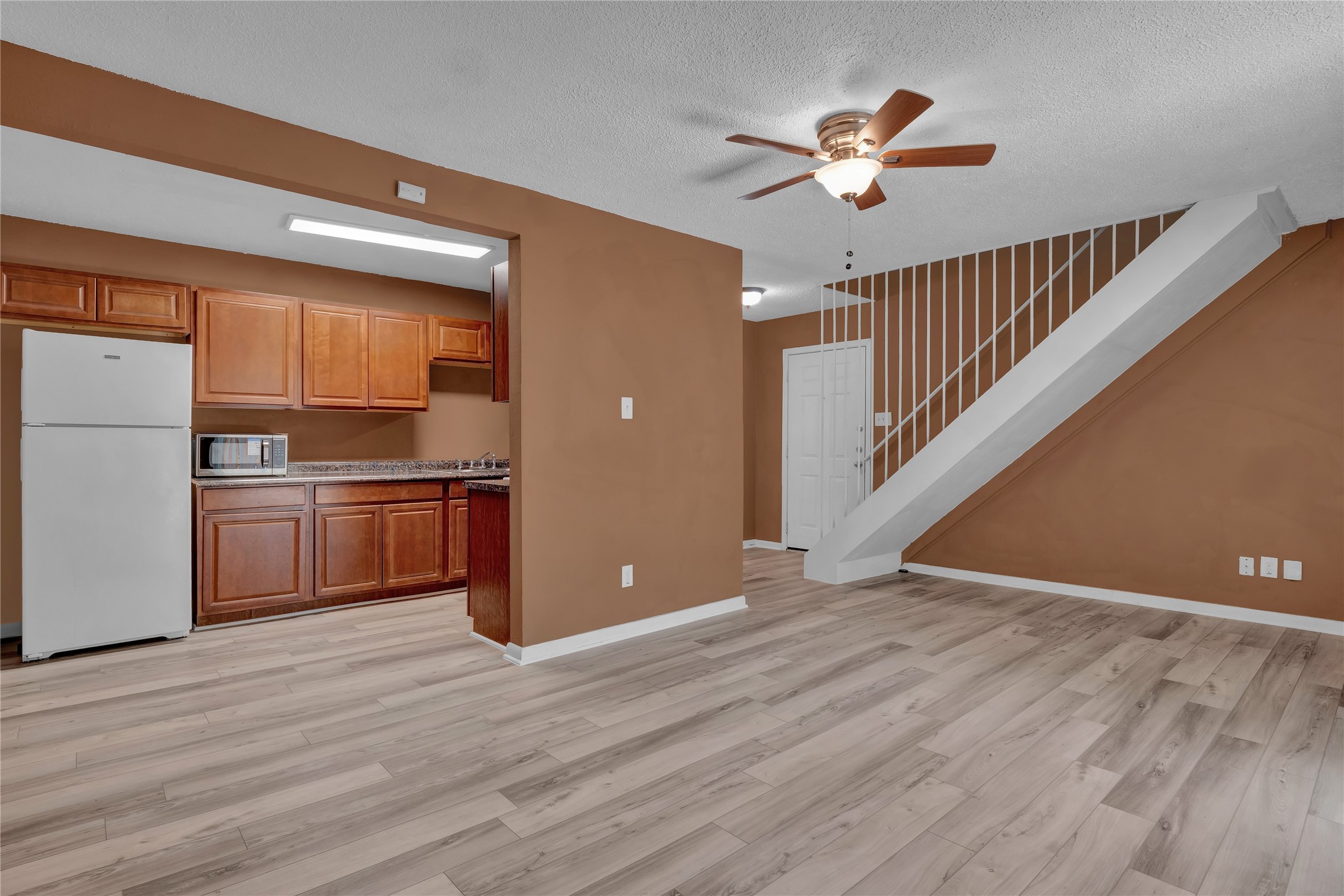 5002 Blue Spruce Circle, Unit C Austin, TX 78723 - Photo 9 of 18 a view of a kitchen with a ceiling fan and wooden floor
