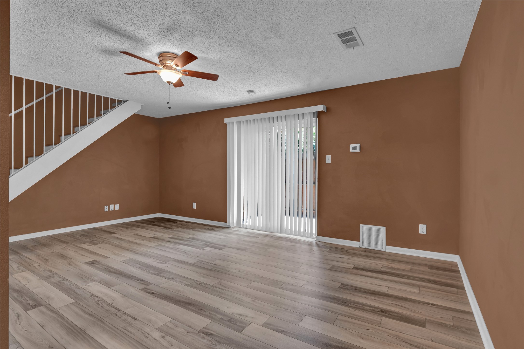 5002 Blue Spruce Circle, Unit C Austin, TX 78723 - Photo 10 of 18 a view of an empty room with wooden floor and fan