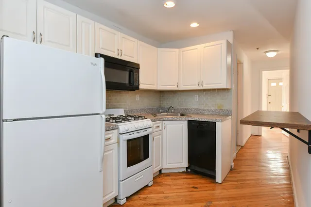 a kitchen with stainless steel appliances granite countertop a stove a refrigerator and a microwave