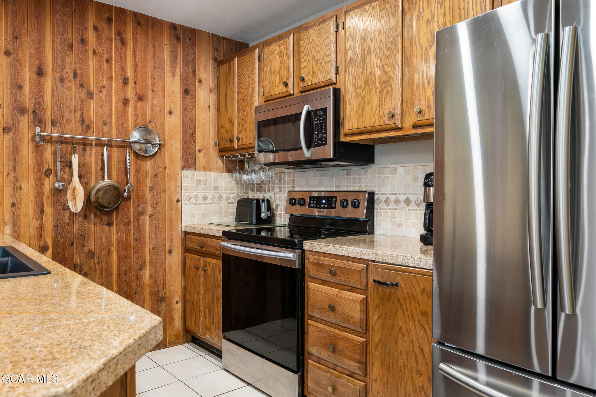 490 Kings Crossing Road, Unit 611 Winter Park, CO 80482 - Photo 14 of 39 a kitchen with stainless steel appliances granite countertop a refrigerator a stove and a sink with wooden cabinets