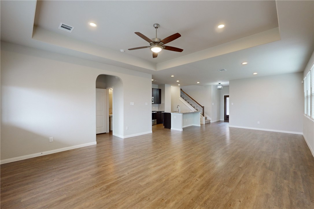 5764 Paseo Place Bryan, TX 77807 - Photo 6 of 35 View of the living and dining areas. The half bath is conveniently located behind the arched opening on the left with close proximity to the back door, kitchen, living and dining areas.