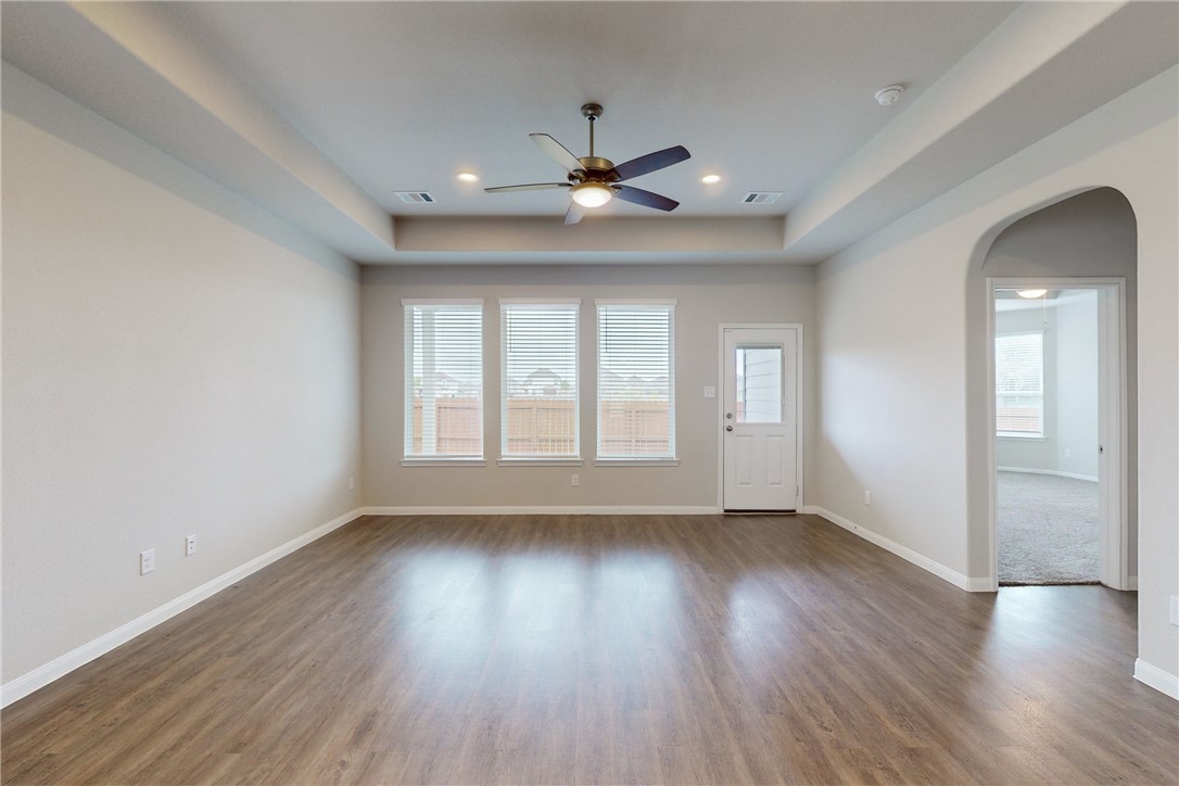 5764 Paseo Place Bryan, TX 77807 - Photo 7 of 35 Living room with trey ceiling and large windows that provide a lot of natural light and overlook the backyard and green space behind the backyard.