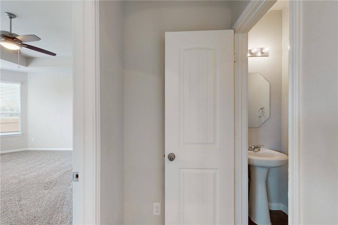 5764 Paseo Place Bryan, TX 77807 - Photo 8 of 35 Connecting hallway between the living area, half bath and primary bedroom.