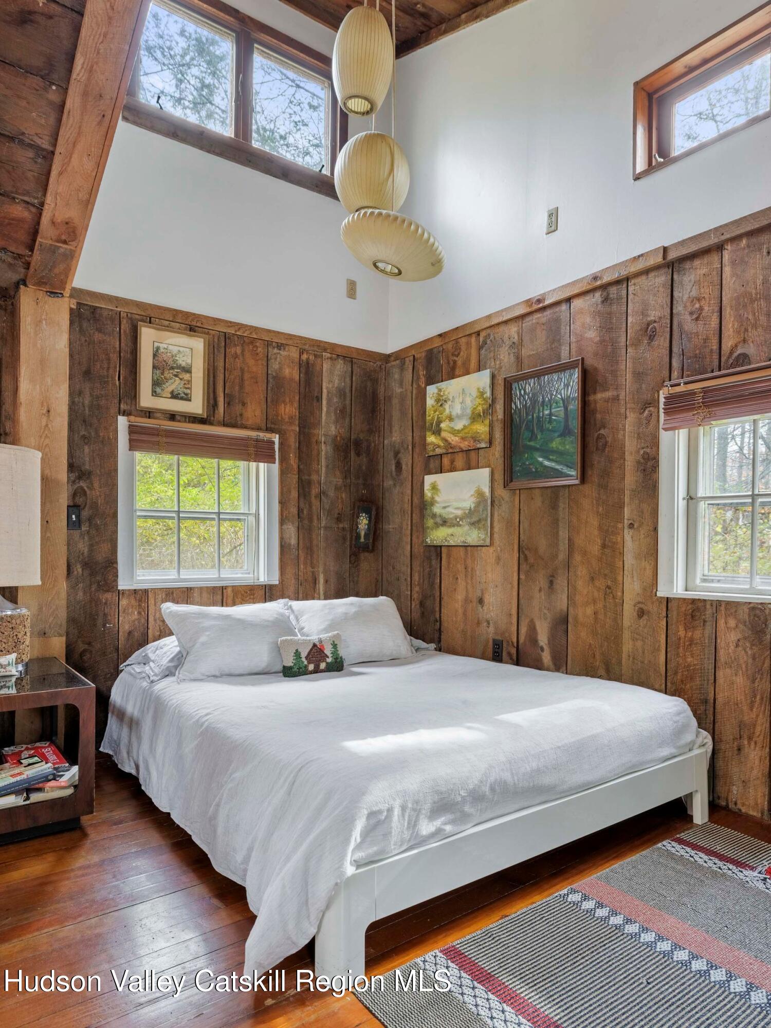 259 Silver Hollow Road Willow, NY 12495 - Photo 24 of 28 a bedroom with a large bed and a chandelier