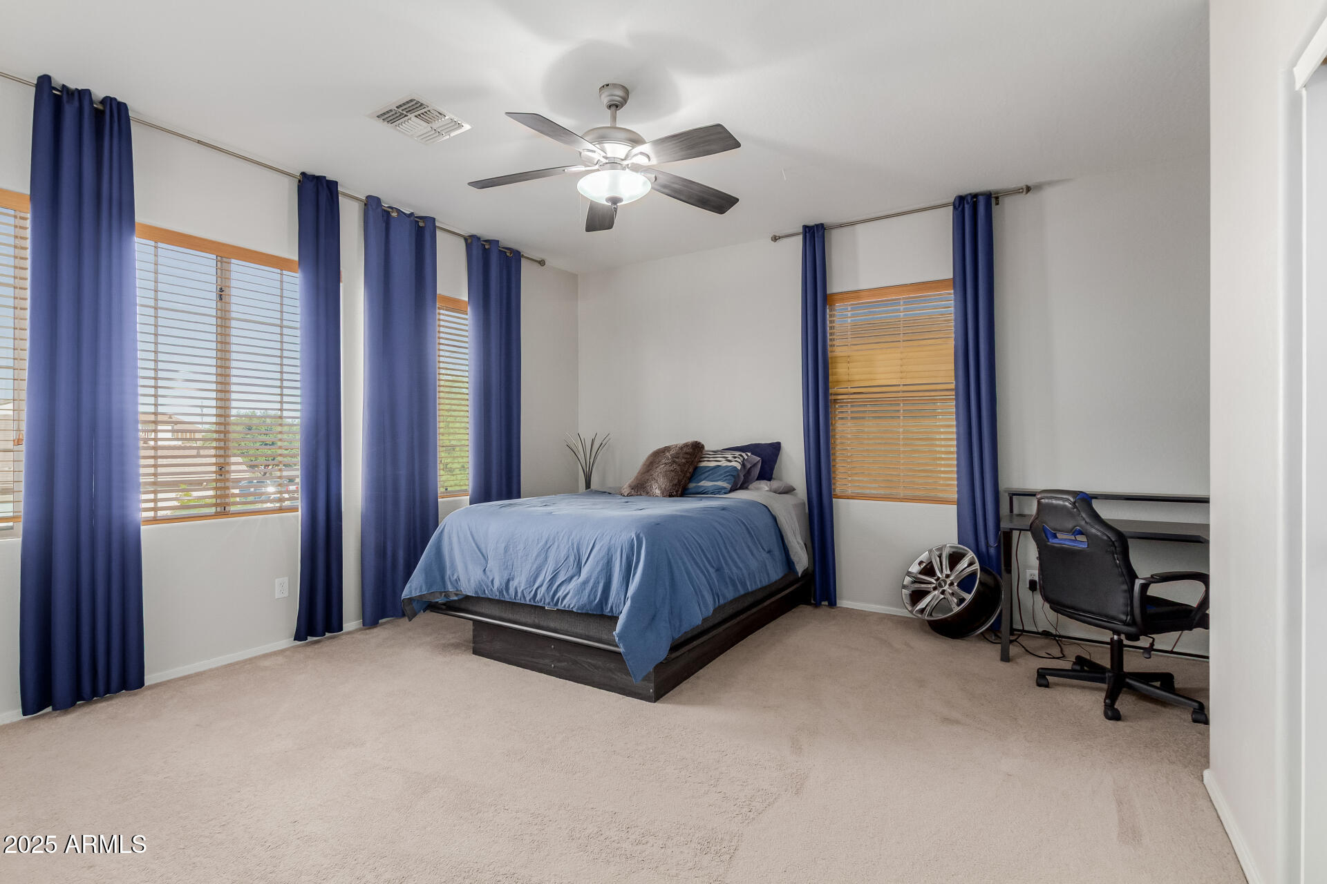 45247 West Jack Rabbit Trail Maricopa, AZ 85139 - Photo 21 of 46 a spacious bedroom with a bed and a chandelier