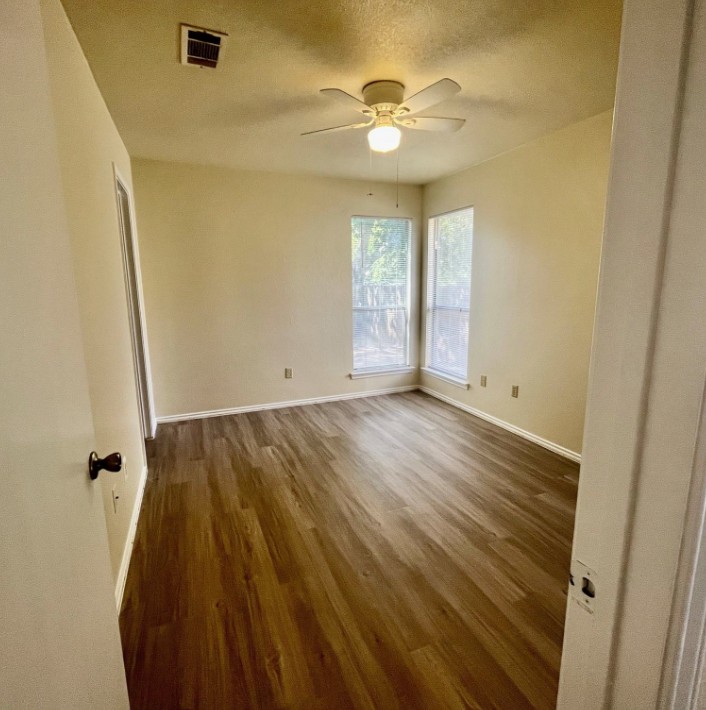 2114 Redwing Way Round Rock, TX 78664 - Photo 6 of 8 Spare room featuring dark wood-type flooring, ceiling fan, and a textured ceiling