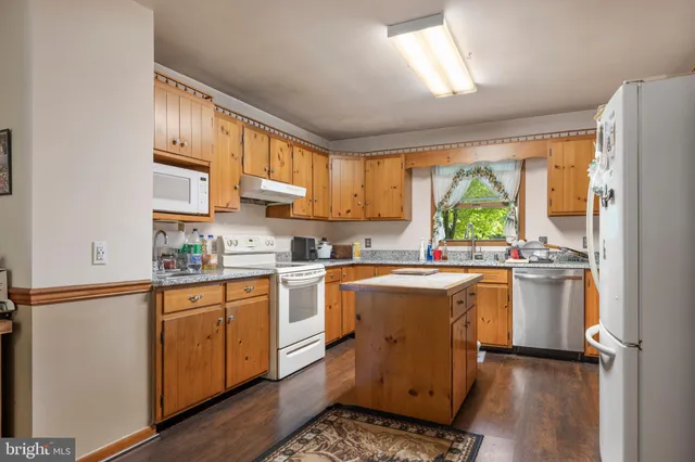 a kitchen with a sink a stove a window and cabinets