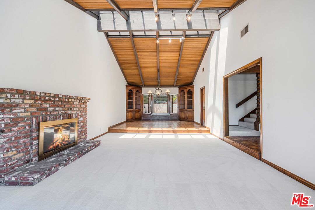 1181 Somera Road Los Angeles, CA 90077 - Photo 6 of 40 a view of an empty room with a fireplace and a window