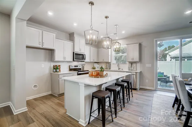 a kitchen with kitchen island granite countertop a sink a center island and appliances