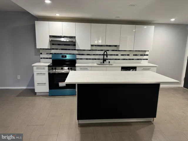 a kitchen with stainless steel appliances a stove a sink and a refrigerator