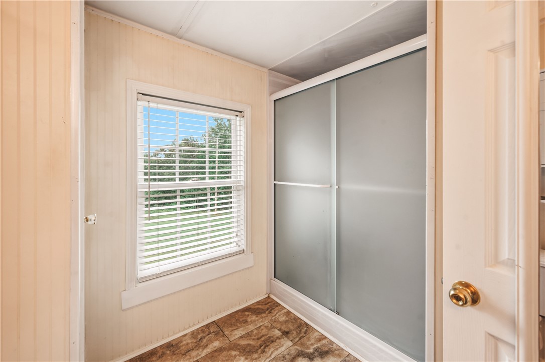 942 Chambers Hill Road Seneca, SC 29672 - Photo 18 of 38 A well-lit bathroom with a glass-enclosed shower and durable tile flooring.