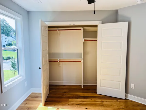 a view of empty room with wooden floor