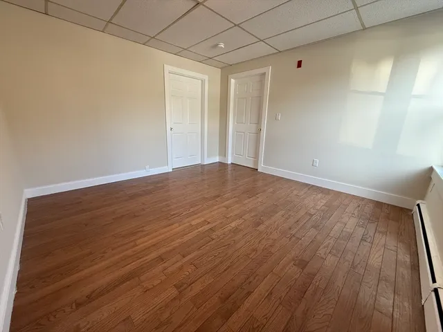 a view of an empty room with wooden floor