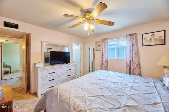 a bedroom with a bed a flat screen tv and a chandelier