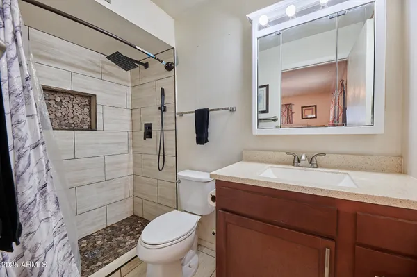 a bathroom with a granite countertop sink toilet and shower