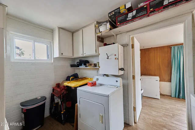 a view of a storage & utility room with a fridge dryer and washer