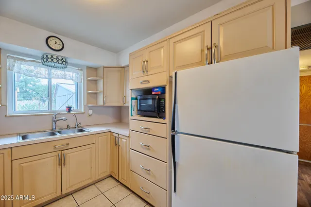 a kitchen with refrigerator cabinets and windows