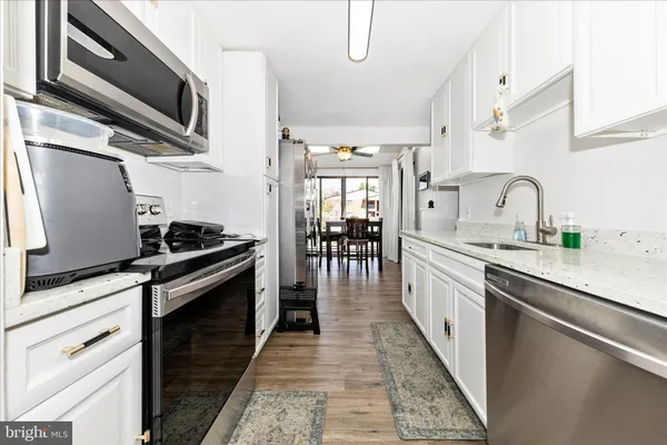 a kitchen with stainless steel appliances a sink stove and cabinets