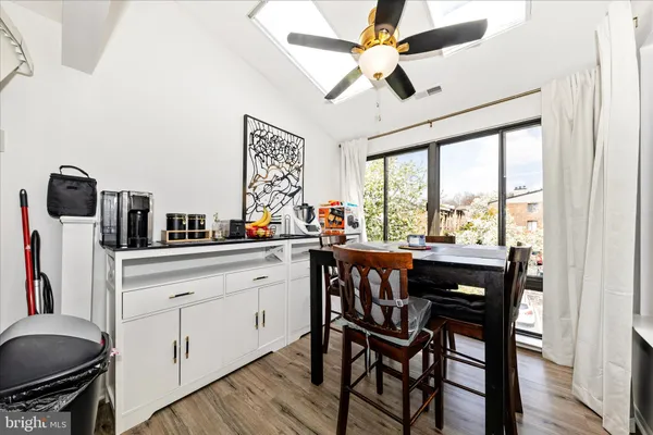 a kitchen with stainless steel appliances granite countertop a stove a sink dishwasher and a dining table with wooden floor