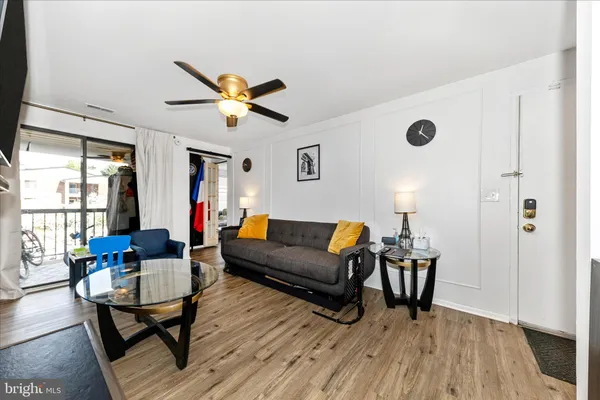 a living room with furniture a ceiling fan and a window