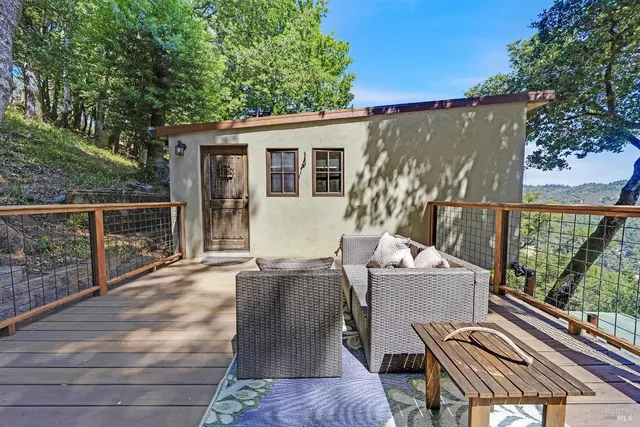 a view of a patio with table and chairs with wooden floor and fence