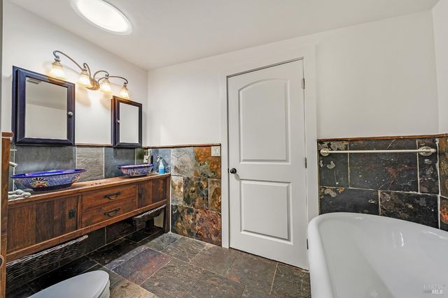 a bathroom with a double vanity sink a mirror and a bathtub