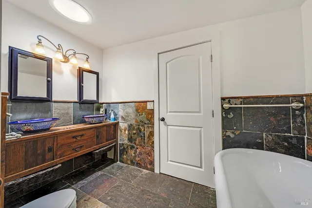 a bathroom with a double vanity sink a mirror and a bathtub