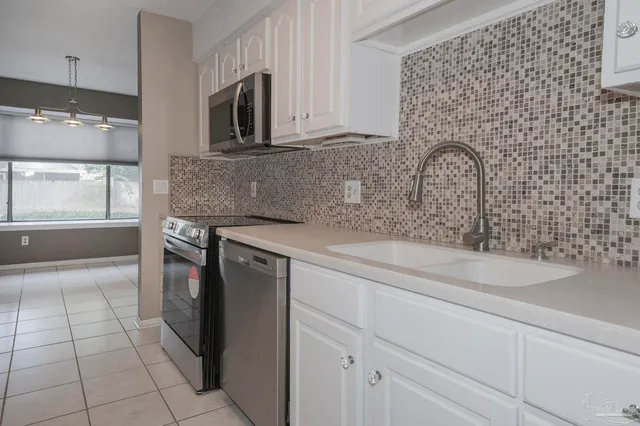 a kitchen with stainless steel appliances granite countertop a sink and a stove