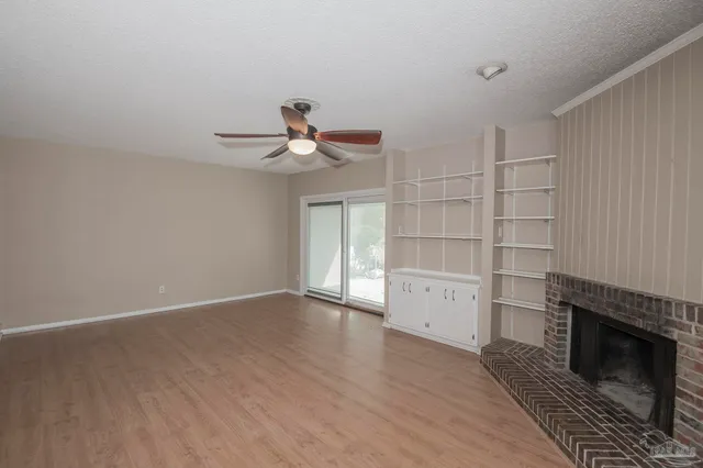 a view of an empty room with a fireplace and a window